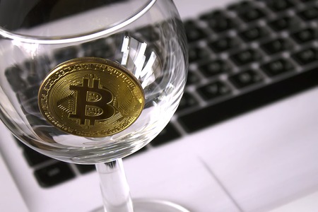 golden bitcoin in a cocktail glass close-upの写真素材