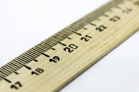 drawing wooden ruler diagonally over white backgroundの写真素材
