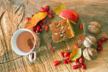 Breakfast, vegan food. Cake with nuts and a cup of tea with fresh rose hips.の写真素材