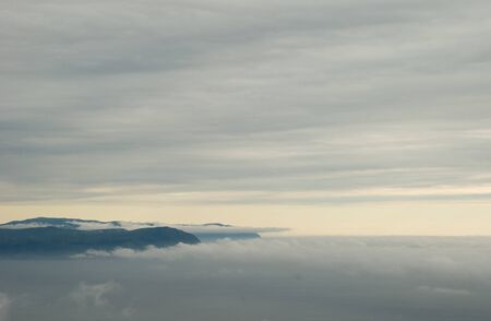 Misty mountains and distant windmills. Photographed from Vestkapp in the Norwegian coast.の写真素材