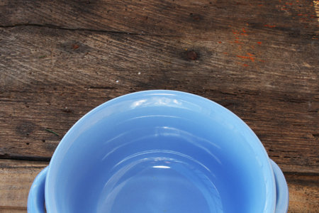 Blue ceramic bowl on wooden background. Top view. Copy space.の写真素材