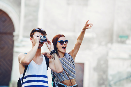 Two young tourists sightseeing a town, pointing with fingerの写真素材