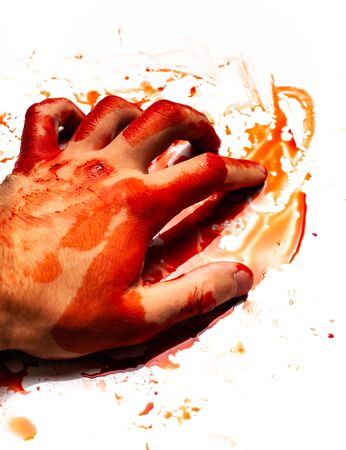 Male bloodied hand on a white background with splashes and drops of blood.の写真素材