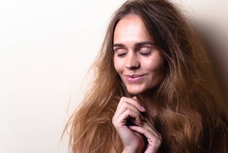 Portrait of an attractive emotional girl. On a light background with empty space.
