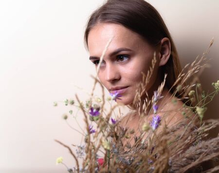 Portrait of a beautiful girl with a dried flower close-up.の写真素材