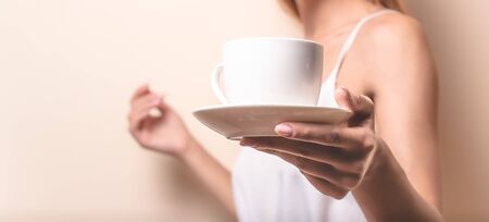Young woman enjoying a cup of coffee. Portrait of female with morning tea. Copy spaceの写真素材