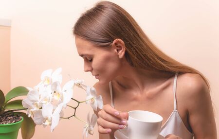Young woman enjoying a cup of coffee. Portrait of female with morning tea. Copy spaceの写真素材