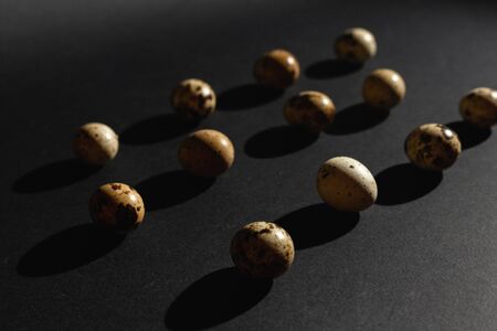 Quail eggs on a black background. Stock photo.