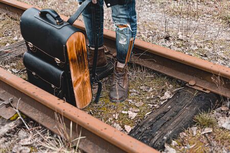 A guy in suede autumn boots on the railway. The concept of hiking, travel practical clothes, shoes.の写真素材