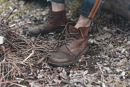 A stock photo of a man in nature sitting by a small fire, warming himself.の写真素材