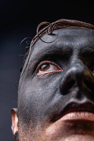 The dirty face of a working miner. Close-up portrait of a black face in soot. Stock photo.