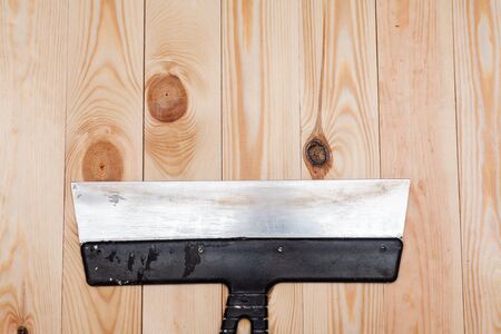 Metal spatula on a wooden background. Stock photo flat style.