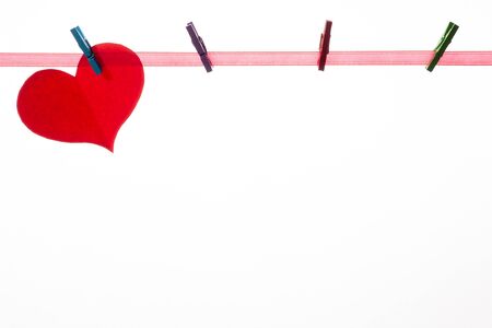 Red paper hearts on clothespins on a white background. Valentine's day concept.の写真素材
