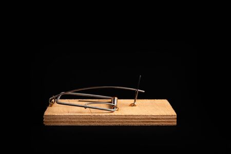 Mousetrap without bait isolate on a black background. Stock photo traps.