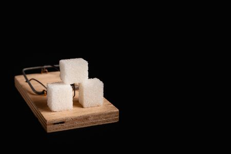 Stock photo of a mousetrap with a bait in the form of sugar. Sugar consumption diseases concept.の写真素材