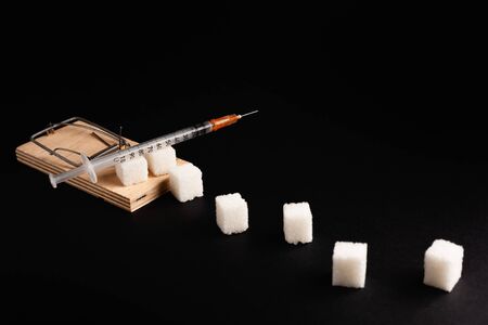 Stock photo of a mousetrap with a bait in the form of sugar. Sugar consumption diseases concept.の写真素材