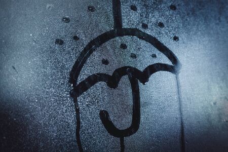 Window with raindrops. Stock photo drawing the "umbrella" on wet glass.の写真素材