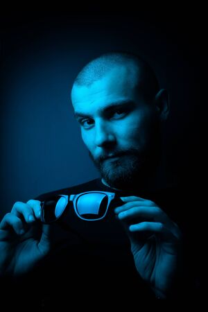 Brutal portrait neon style. Portrait of the face of a charismatic guy with a beard.