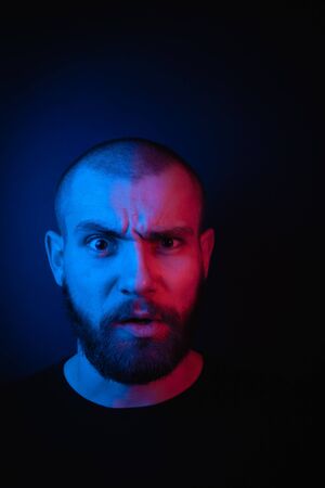 Face portrait of a bearded charismatic hipster. Stock photo studio close-up portrait on a dark...