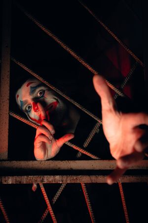 Close-up portrait of a joker man. Stock photo makeup joker in a horror room.の写真素材