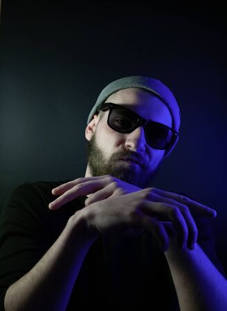 Portrait of a hipster guy with color light. Hipster face portrait in studio.の写真素材