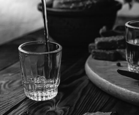 Traditional drink vodka in glasses, with a snack in the form of cold cuts and bacon, cucumbers, preservation. Russian festive national table.の写真素材