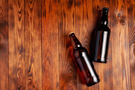 Two bottles of beer lie on an open table with empty space.の写真素材