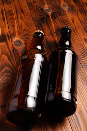 Two bottles of beer lie on an open table with empty space.の写真素材