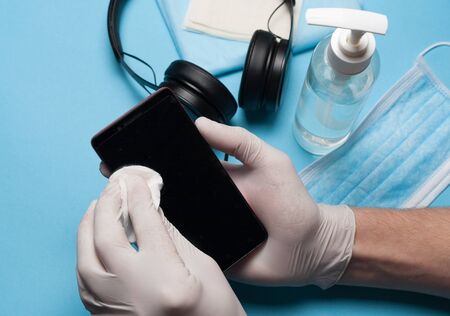 Close-up of disinfection, cleaning smartphone in white gloves. Prevention of coronavirus infection.Close-up of disinfection, cleaning smartphone in white gloves. Prevention of coronavirus infection.の写真素材