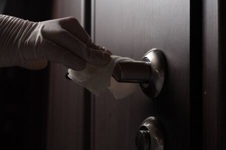 Close-up of disinfection, cleaning and washing of door handles in white gloves. Coronavirus infection preventionの写真素材