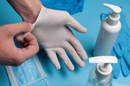 Close-up of disinfection, hands in white gloves and a bottle with liquid. Prevention of coronavirus infection.の写真素材