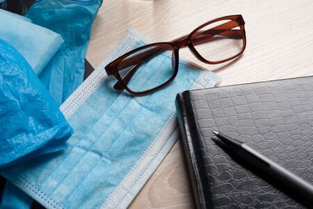 Empty notepad on hospital desk surrounded by medical equipment. Top view, flat lay composition. Notepad, mask, sanitizer and pen on table. Concept of virus 2019-nCoV, coronavirus, illness. Medical check up.の写真素材