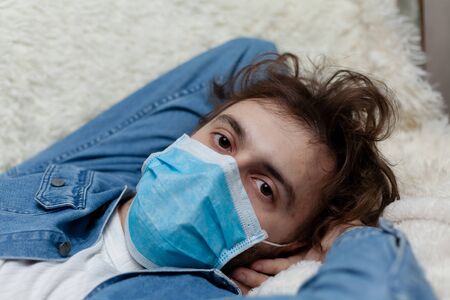 Lone guy at home in quarantine. Staying at home makes you sad and crazy. Home isolation and its consequences for the psychological health of a person.の写真素材