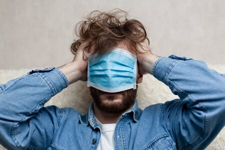 Lone guy at home in quarantine. Staying at home makes you sad and crazy. Home isolation and its consequences for the psychological health of a person.の写真素材