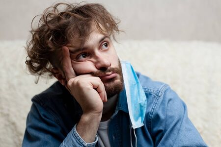 Lone guy at home in quarantine. Staying at home makes you sad and crazy. Home isolation and its consequences for the psychological health of a person.の写真素材