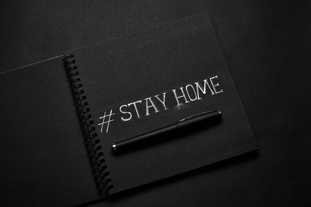 Stay at home, text. Headline inscription on black paper background.