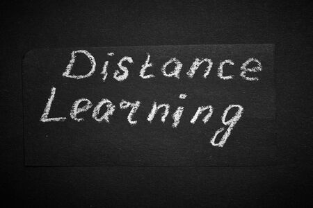 Distance learning. Headline on black paper.
