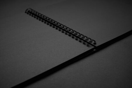 Blank black notebook on a black table, mockup photo. Blank black cover template with copy space for...