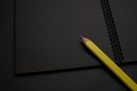 Blank black notebook on a black table, mockup photo. Blank black cover template with copy space for...