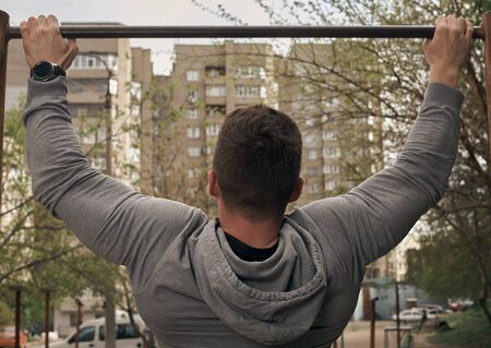 Athletic attractive guy is training outdoors. The concept of sports, health, fitness. Young man in a...