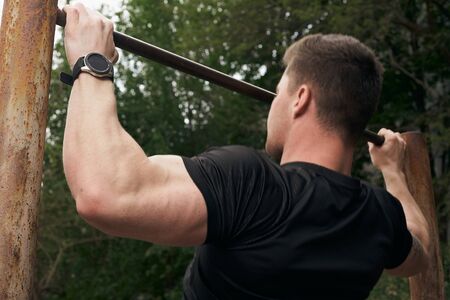Athletic attractive guy is training outdoors. The concept of sports, health, fitness. Young man in a...