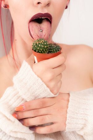 Funny girl licks a cactus.の写真素材