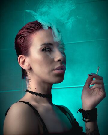 Girl smokes a cigarette. Confident lady.の写真素材