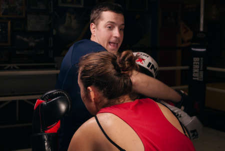 UKRAINE, ZAPOROZHYE - March 11, 2020: Boxing coach holds boxing paws. Training, self defense. Boxing training with a girl.のeditorial素材