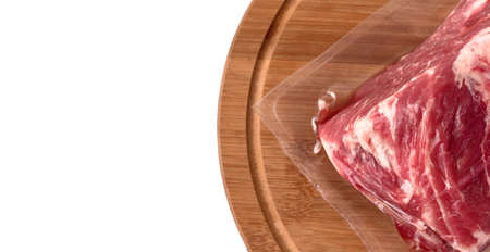 Packaged pork meat on a round wooden board isolated on white background. Set of different photos for design. Top and side view.の写真素材