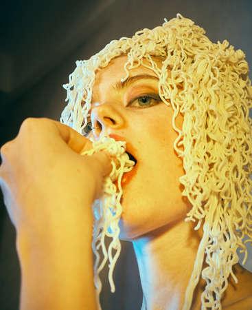 Funny hungry girl with curly noodles on her head.の素材 [FY310157741244]