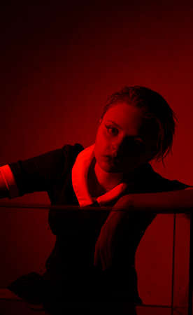 Horrible portrait of a young girl in a horror room with a red light.の写真素材