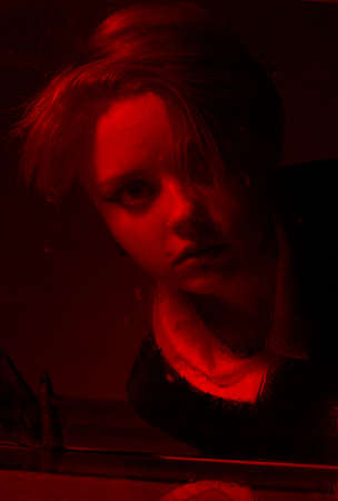 Horrible portrait of a young girl in a horror room with a red light.の写真素材