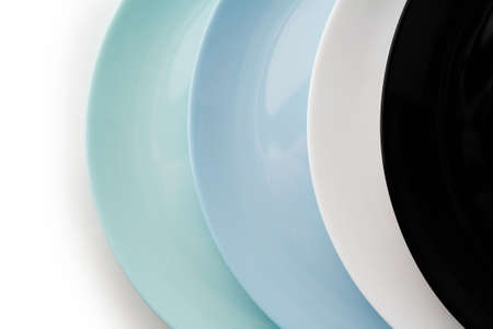 Stack of flat multi-colored set plates isolated on white background.の写真素材