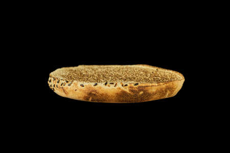 Toasted slice of burger bun isolated on black background.の写真素材